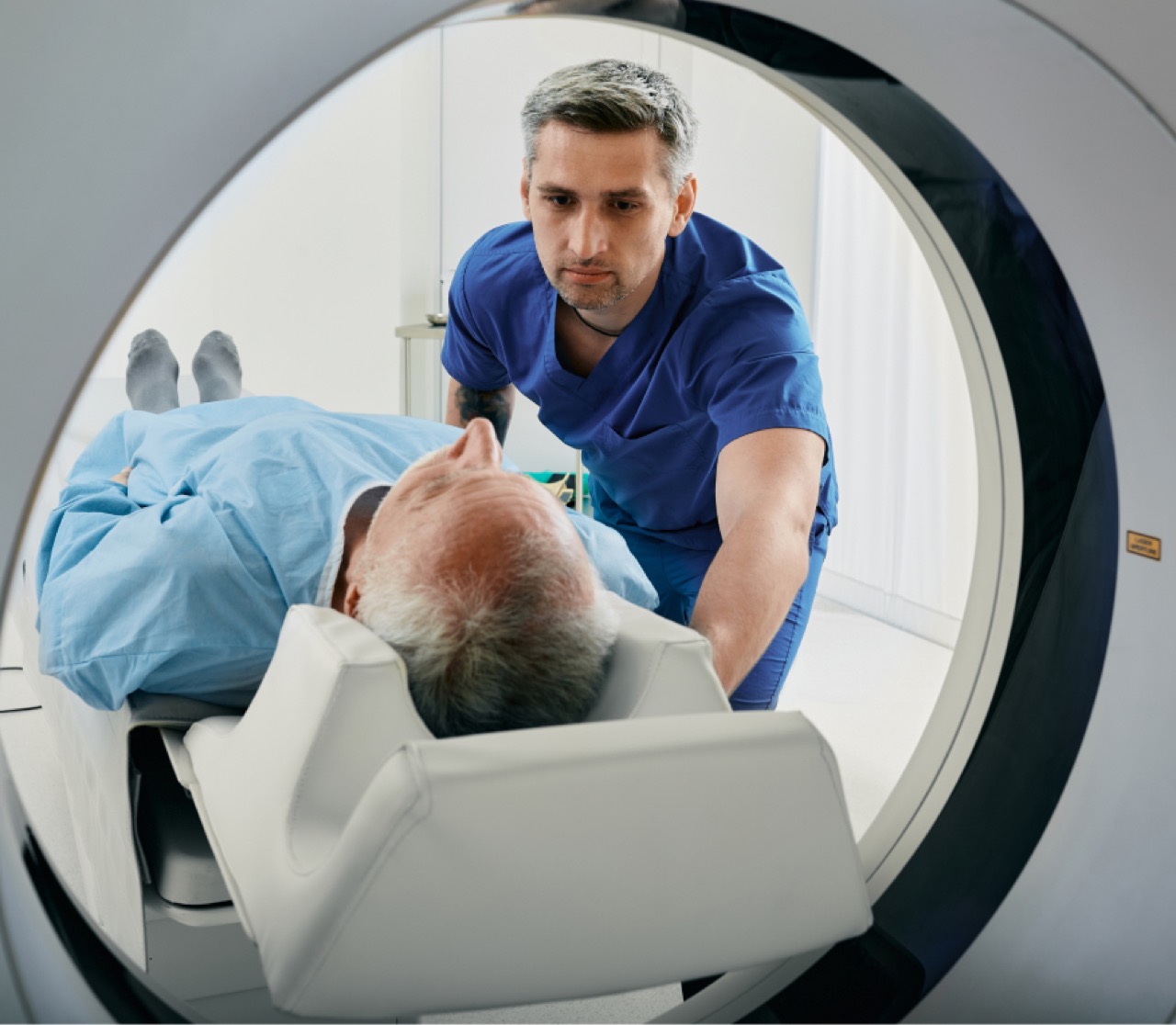 A doctor placing a man in an MRI scanner