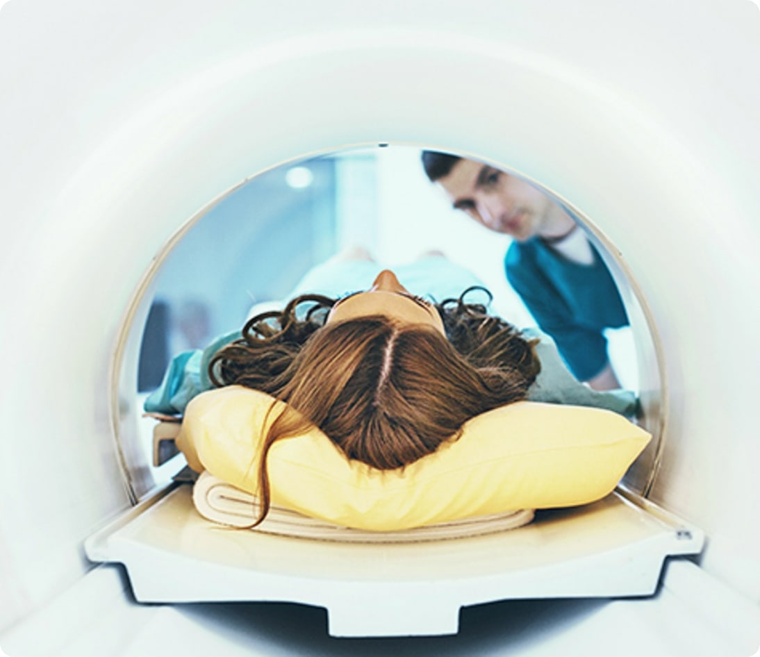 Man sitting on MRI machine smiling